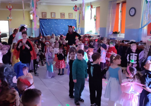 duża grupa przedszkolaków tańczy w przedszkolnej szatni, wszyscy są przebrani
