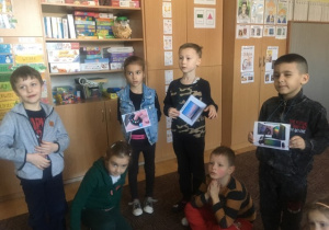 kilkoro dzieci z obrazkami urządzeń, które wykorzystują internet. prezentują je pozostałym dzieciom