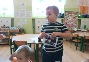 chłopiec prezentuje dzieciom fotografię z urządzeniem wykorzystującym internet
