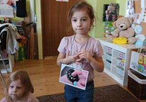 dziewczynka prezentuje dzieciom fotografię z urządzeniem wykorzystującym internet