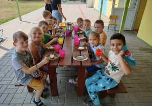 grupa dzieci je posiłek na świeżym powietrzu