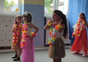 dziewczynki ubrane w stroje hawajskie występują przed rodzicami