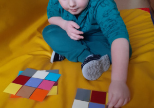 chłopiec siedzi na materacu i reazlizuje zakodowane zadania matematyczne
