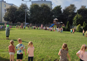 duża grupa dzieci w ogrodzie przedszkolnym, stoją w duzym kole