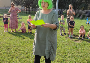 nauczycielka w zielonej peruce czyta list do dzieci otrzymany od "ekoludka"