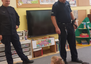 Policjanci prowadzą wykład, dzieci słuchają