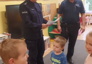 Dzieci w ramach podziękowania wręczają policjantom dyplomy
