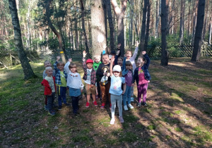 dzieci pozują do zdjęcia pod drzewem, wokół las