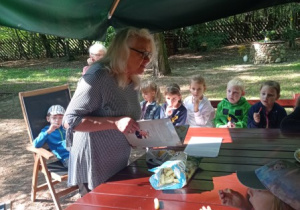 p. B. Kaszyńska opowiada o książkach, wokół niej zgromadzone dzieci