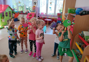 grupa dzieci , trzymają w rączkach sylwety "Kropek"