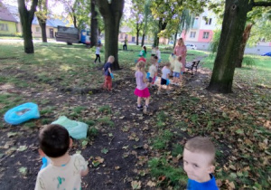 dzieci zbierają śmieci w parku , mają założone rękawiczki jednorazowe