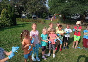 dzieci zebrane w ogrodzie biorą udział w zabawach o tematyce eko