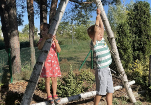 dzieci wspinają się po drewniane jkonstrukcji