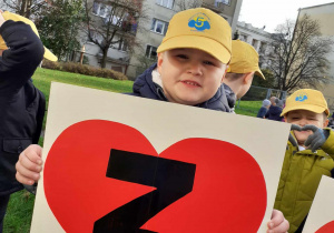 chłopiec na podwórku przedszkolnym, w dłoniach trzyma serce z literką Z