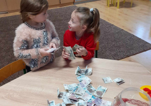 dwie dziewczynki segregują pieniądze zebrane na akcji Serce dla Zuzi