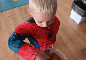 chłopiec przebrany za Spidermana sięga po ciastko