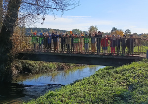 grupa dzieci i nauczycielka w terenie, stoją na mostku