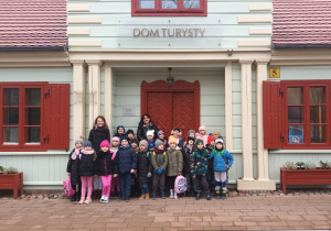 dzieci i panie pozują do zdjęcia przed budynkiem muzeum Miasta Zgierza