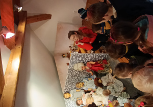grupa dzieci w muzeum, słuchają pani przewodniczki opowiadającej o wystawie zabawek