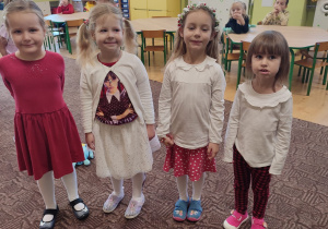 czworo dzieci ubranych galowo stoi w klasie