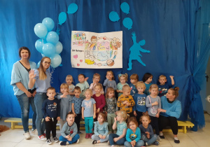 grupa Pszczólki - wszystkie dzieci ubrane na niebiesko, biorą udział w spotkaniu z okazji Dnia Praw Dziecka, pozują na tle okolicznościowej dekoracji