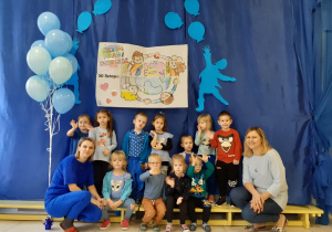 grupa Misie - wszystkie dzieci ubrane na niebiesko, biorą udział w spotkaniu z okazji Dnia Praw Dziecka, pozują na tle okolicznościowej dekoracji
