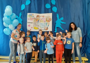grupa Duszki - wszystkie dzieci ubrane na niebiesko, biorą udział w spotkaniu z okazji Dnia Praw Dziecka, pozują na tle okolicznościowej dekoracji