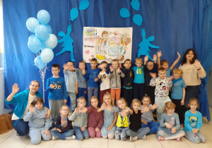 grupa Biedronki - wszystkie dzieci ubrane na niebiesko, biorą udział w spotkaniu z okazji Dnia Praw Dziecka, pozują na tle okolicznościowej dekoracji
