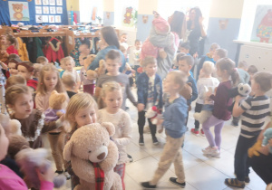 duża grupa dzieci tańczących w szatni, w rękach trzymają misie