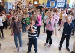 duża grupa dzieci tańczących w szatni, w rękach trzymają misie