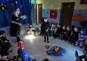 grupa przebranych dzieci słucha opowieści nauczycielki wprowadzającej je w fabułe biwaku