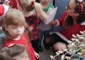grupa dzieci w szatni, szukają ukrytych prezentów od Mikołaja