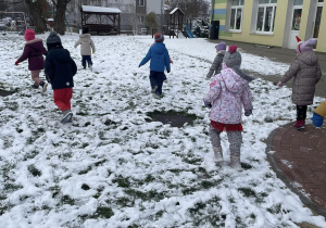 grupa dzieci w przedszkolnym ogrodzie , szukają ukrytego worka z prezentami