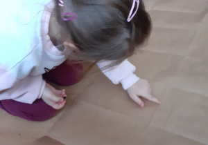 dziewczynka dotyka paluszkiem lnie zgięcia na karcie zabawy