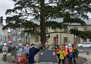 grupa dzieci pozuje do zdjęcia na placu JP II