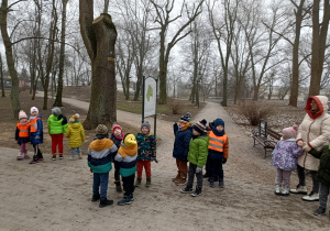 grupa dzieci i nauczycielki w parku miejskim , spacerują alejkami