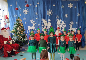 grupa dzieci przebranych za elfy i choinki podczas świątecznego występu