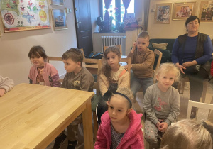 dzieci siedzą przy stolikach w Baśniowej Kawiarence , obok pani woźna