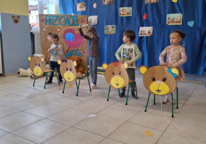 Dzieci uczestniczą w konkursie z okazji Dnia Misia. W tle znajduje się tematyczna dekoracja.