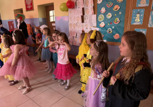 grupa dzieci przebranych za różne postaci bawi się na balu karnawałowym