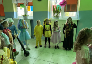 grupa dzieci przebranych za różne postaci bawi się na balu karnawałowym