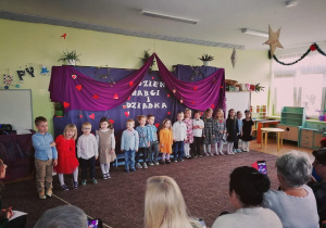 Dzieci podczas występu z okazji Dnia Babci i Dziadka. W tle znajduje się dekoracja przygotowana na tą uroczystość.
