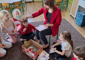 nauczycielka rozdaje dzieciom kartki z poczty walentynkowej