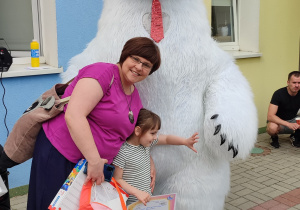 mama z córką pozują do zdjęcia przy wielkim białym misiu