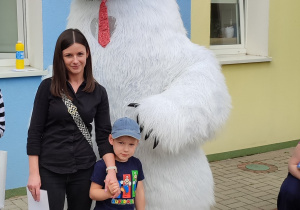 mama z dzieckiem pozują do zdjęcia przy wielkim białym misiu