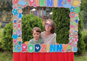 mama z synem pozują do zdjęcia w ramce "piknik rodzinny"