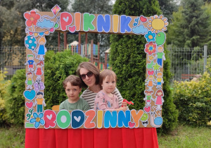 mama z dwojgiem dzieci pozują do zdjęcia w ramce "piknik rodzinny"