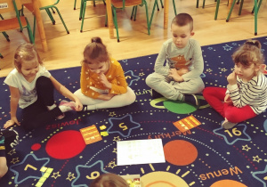 dzieci siedzą na dywanie poznają zasady gry "Kurnik"