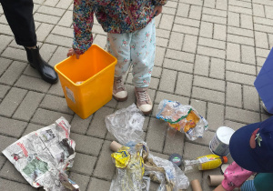 dziewczynka bierze udział w zabawie edukacyjnej - segregacji śmieci