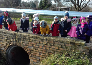 grupa dzieci na dworze stoi przy mostku